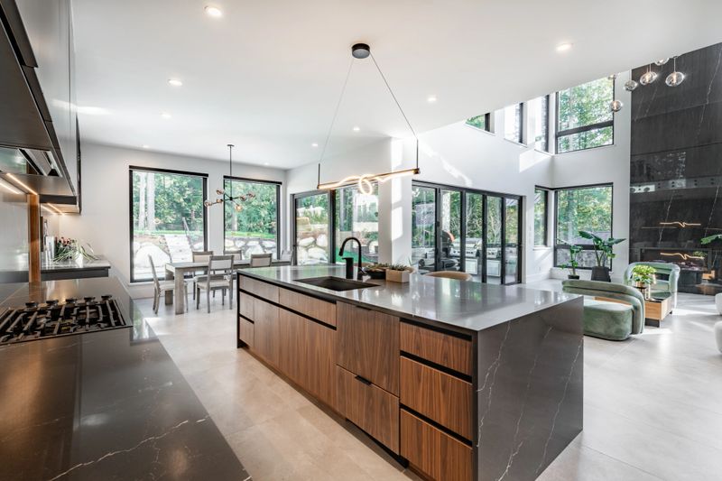 A very large modern contemporary private residence residential home spacious interiors living room, kitchen, office, recreation room, foyer, hallway, floating staircase window wall open to a patio with BBQ and swimming pool. New construction family home