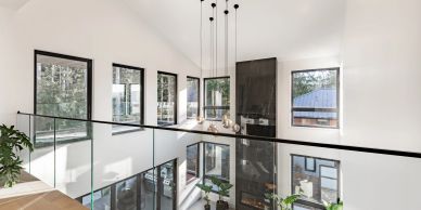 Modern interior with hanging lights and glass railing.