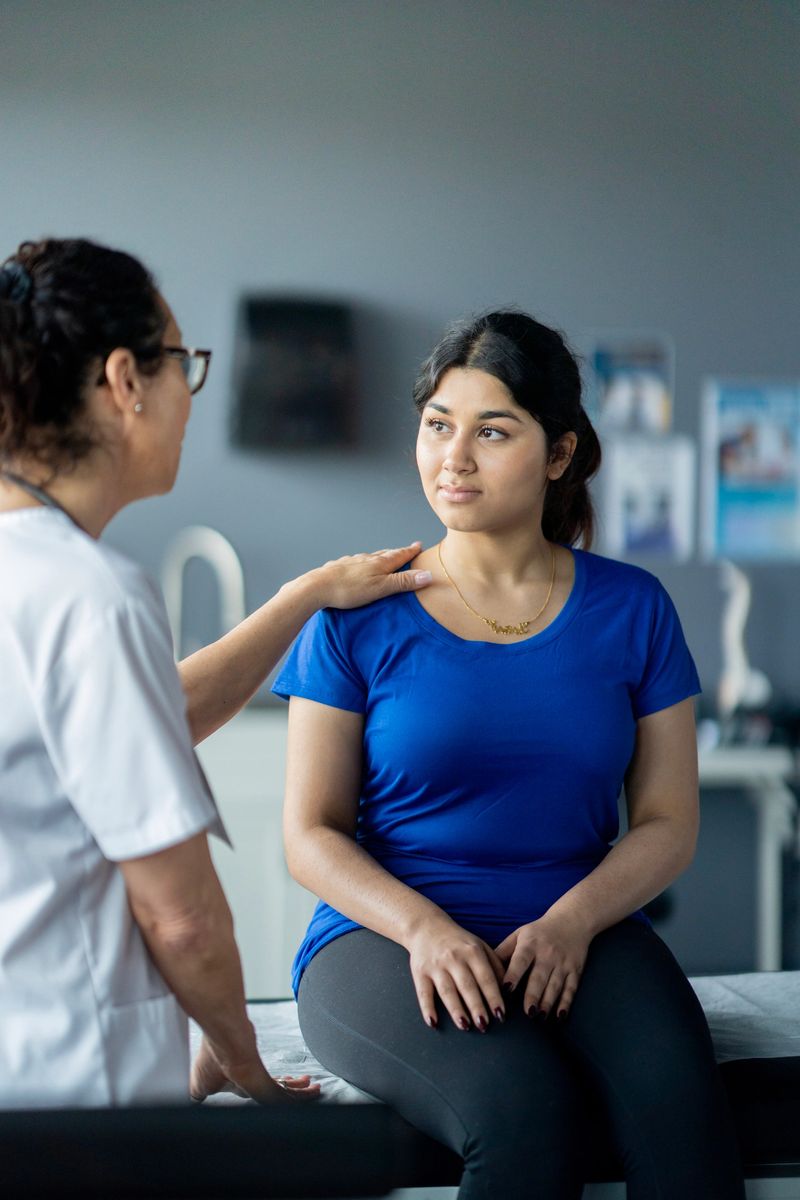 A doctor demonstrates care and professionalism while having a supportive discussion with a patient. The indoor scene showcases trust, medical guidance, and interpersonal communication essential to healthcare.