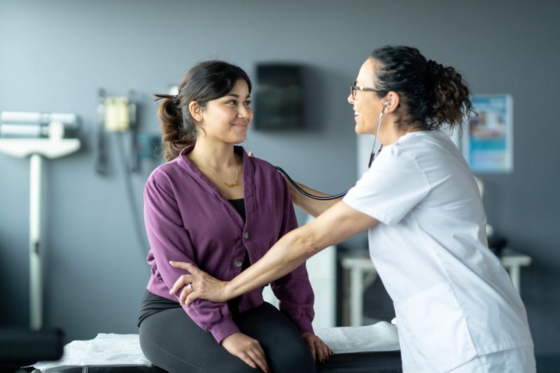 A physician performs a patient examination in a health clinic, fostering trust and communication. The scene highlights professional healthcare and the importance of doctor-patient interactions.