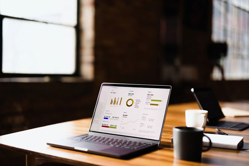 Open laptop displaying business data and analytics, creating an atmosphere of productivity in a modern office workspace filled with light