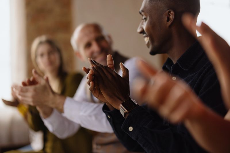Business people clapping and applauding during a meeting, celebrating their collective success and fostering a spirit of teamwork and unity