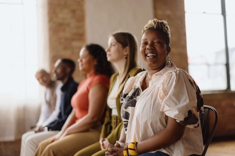 Cheerful african american businesswoman laughs during a meeting with colleagues in a modern office