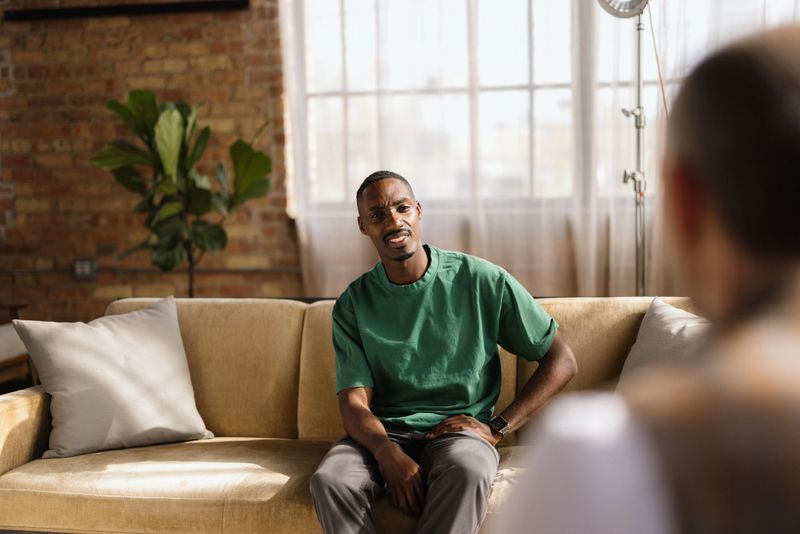 Patient discussing personal challenges with a therapist during a home visit, fostering an environment of trust and open communication