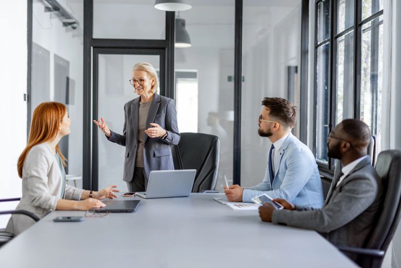 A confident speaker engaging a team in a formal meeting.