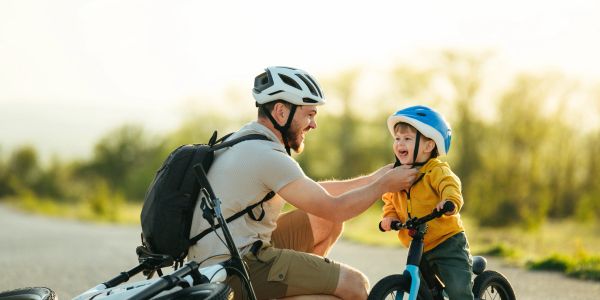 Father and child bonding while biking outdoors.