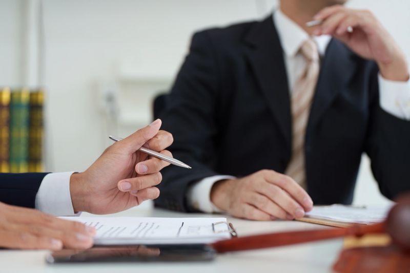 A focused legal consultation where a lawyer advises a client about legal obligations and strategies, emphasizing clarity in communication.