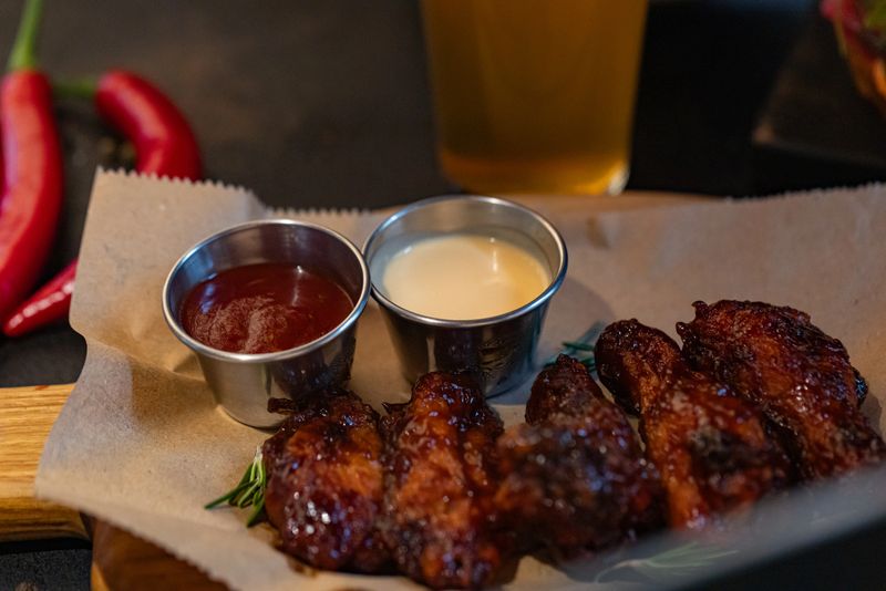 Closeup of chicken wings with dips served at restaurant for design purpose