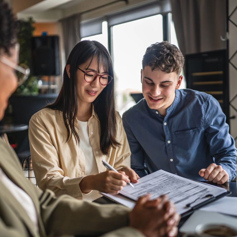 young entrepreneurs sign document, contract with financial adviser