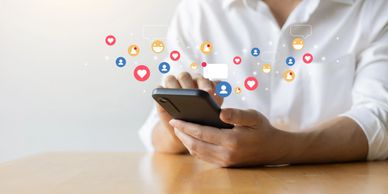 Person using smartphone with floating social media icons and notifications.