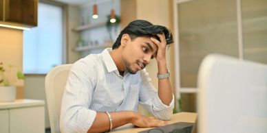 Stressed man working on computer.