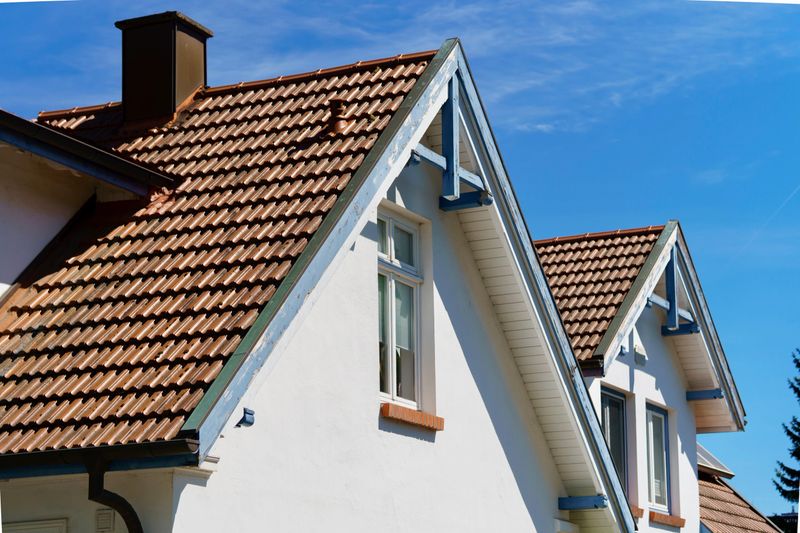 Residential house with pitched roof and white façades in traditional architectural style under clear sky