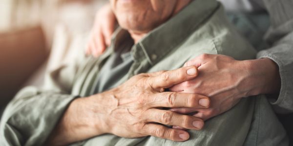 Young hand holding elderly hand gently.