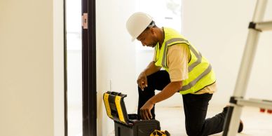 Construction worker inspecting tools indoors.
