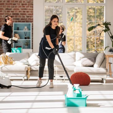 A woman in yellow gloves cleaning a kitchen countertop with a cloth.