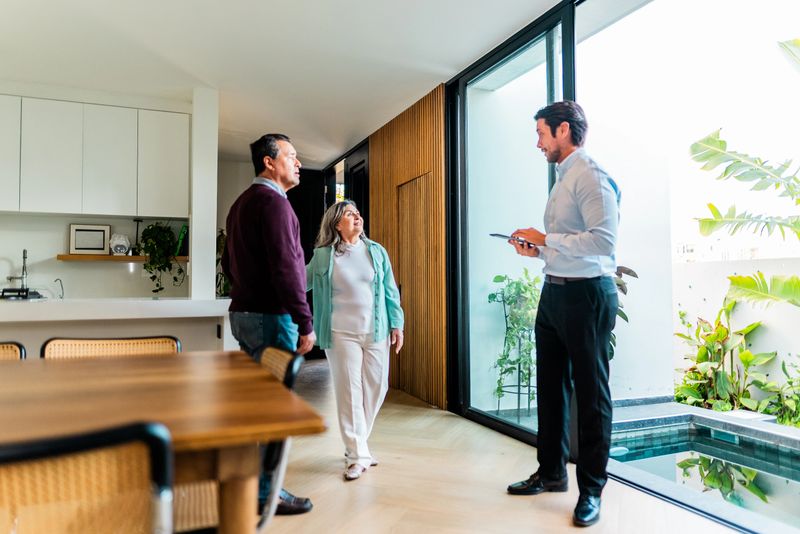 Real estate agent showing house to senior couple customers