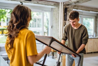 Two people assembling a piece of furniture indoors.