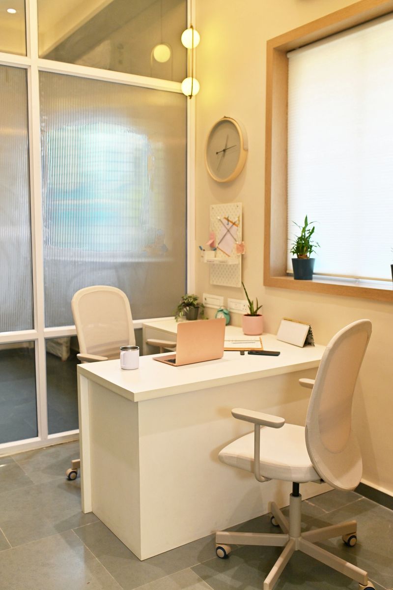 An empty modern office cabin with minimal furniture, and a clean, contemporary design. The space includes a simple desk and chair, with neutral tones.