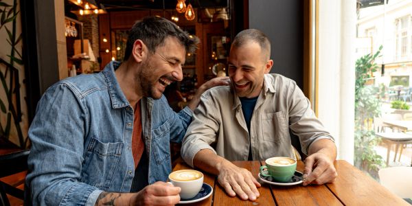 Two men enjoying coffee and laughing.