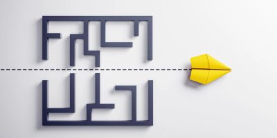 Yellow paper airplane bypassing a maze illustrating thinking outside the box. And demonstrating fractional time.
