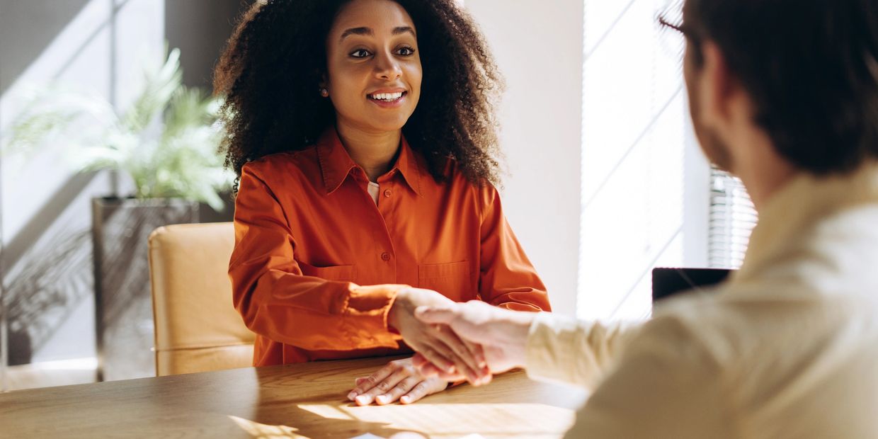 Two people shaking hands during a positive meeting in a bright office.