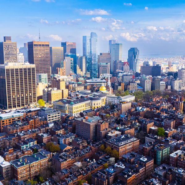 A vibrant cityscape with a mix of historic and modern buildings under a blue sky.