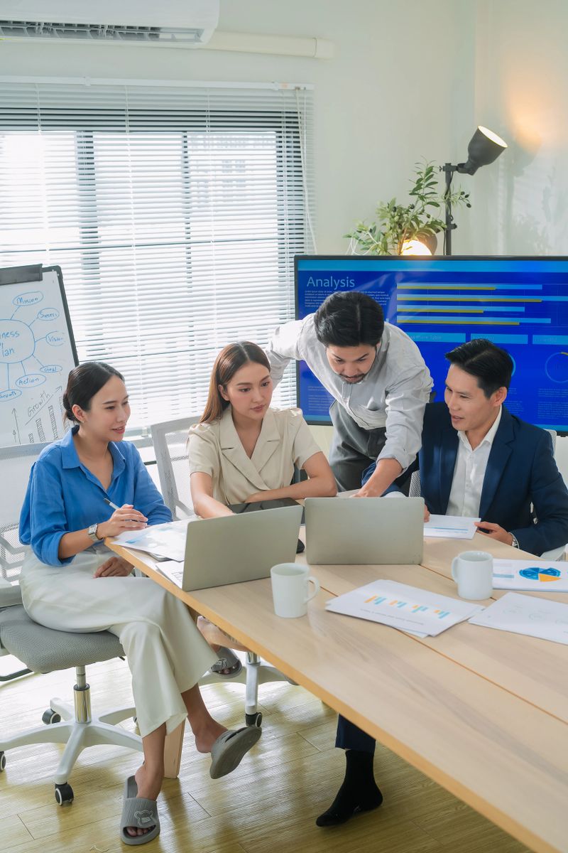 Colleagues having a meeting in office boardroom asian young businessman lead his team to discuss their projects  Businesswoman and businessman leading a meeting in office