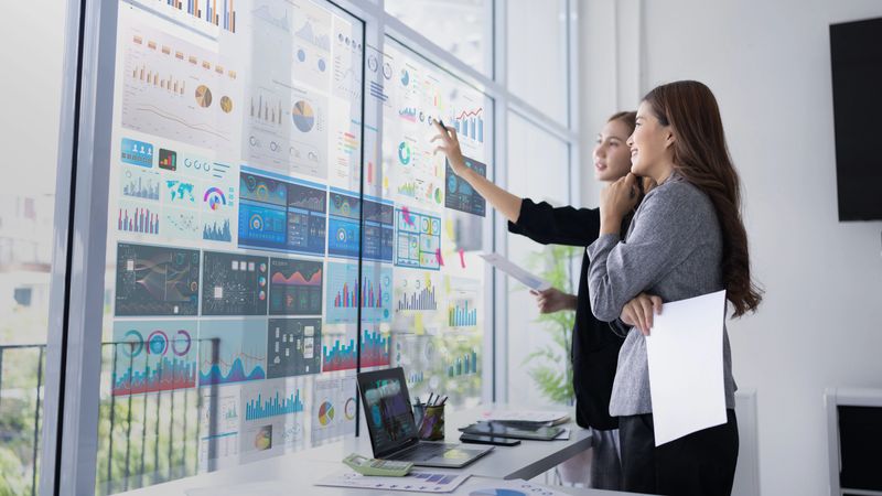 Two businesswoman presentation with marketing strategy analysis at meeting room, Business technology in boardroom for training marketing concept.