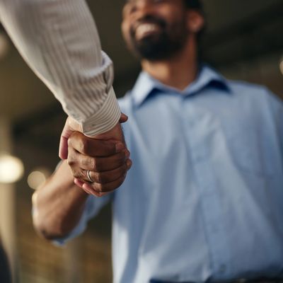 Two people shaking hands in a friendly manner.