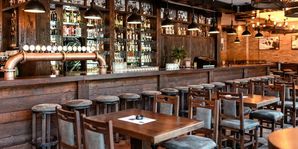 Cozy rustic bar with wooden furniture and warm lighting.