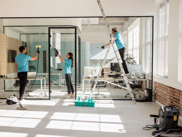 Team cleaning large modern office space.