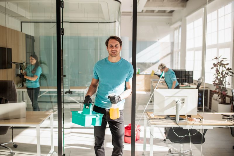 Office cleaning team using tools and equipment to maintain cleanliness in a professional work environment.