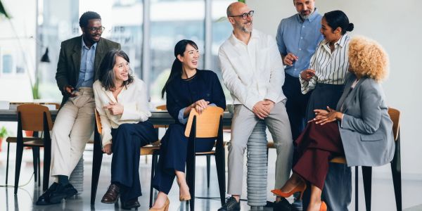 Diverse professionals engaging in a lively discussion at the office.