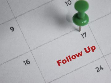 Calendar with a green pushpin on the 17th marked 'Follow Up'.