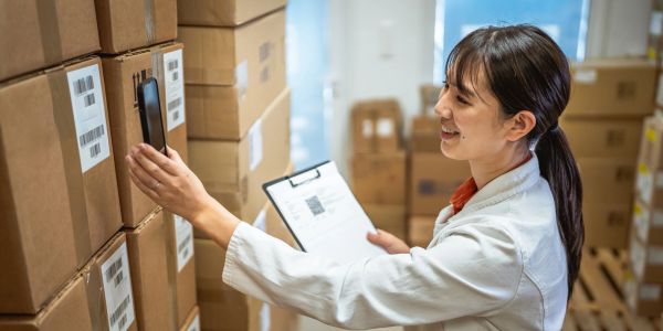 Woman scanning boxes in a warehouse.