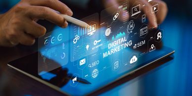 Hands using a tablet with digital marketing holographic interface.