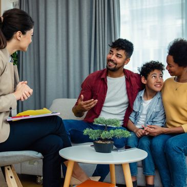 Family having a discussion with a therapist in a cozy setting.