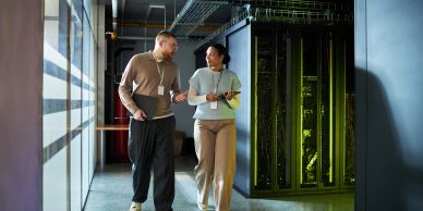 Two IT professionals discussing near server racks.