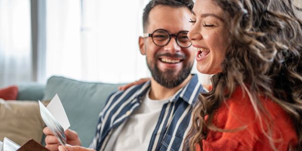 Couple smiling and enjoying memories from a photo album together.