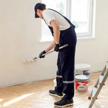 Man painting a wall with a roller