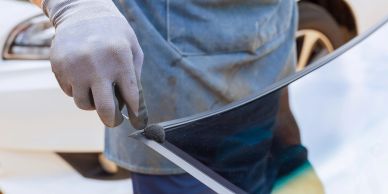 Person cutting glass with a glass cutter.