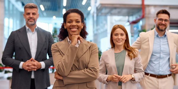 Confident diverse professionals standing together in a modern office.