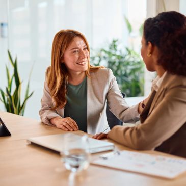 Two women having a positive conversation in an office.