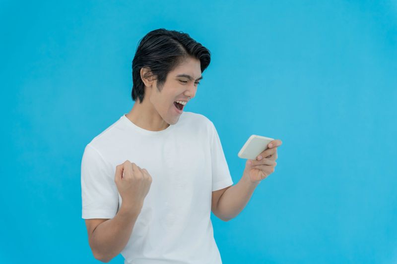 excited young man play games by mobile phone make winner gesture. female winning mobile gambling. Wow face expression. Esport streaming game online, surprise, gamer, online, earning, new generation.