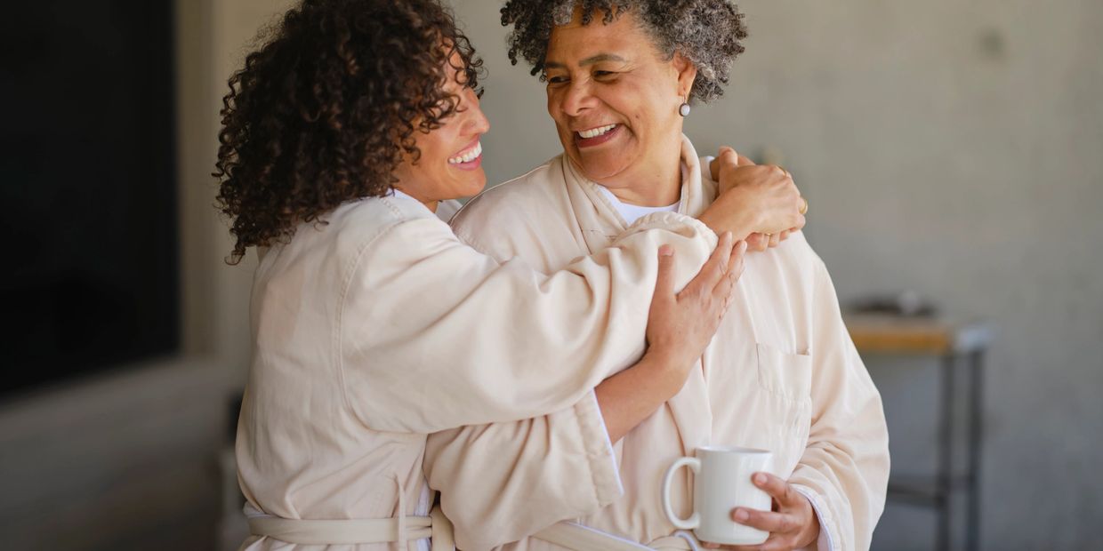 Two women hugging and smiling warmly.