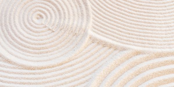 Concentric circles drawn in fine white sand creating a calming pattern.
