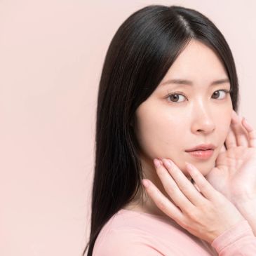 Portrait of a woman with flawless skin and long black hair.
