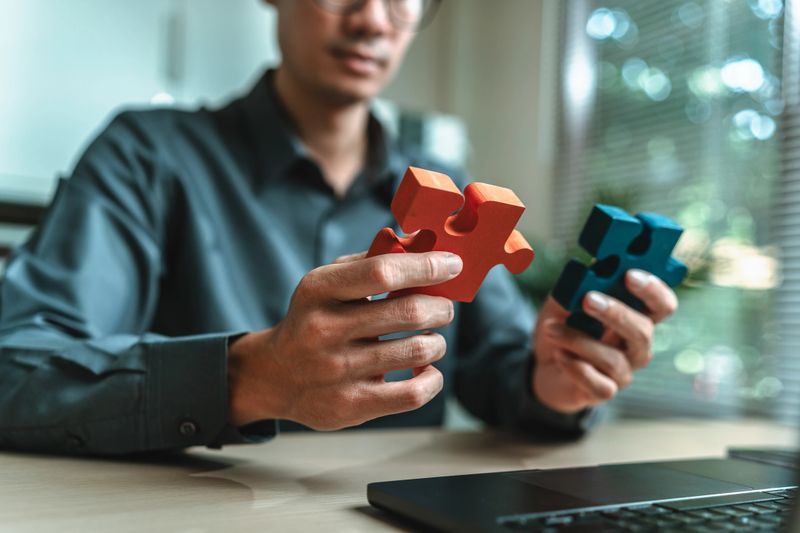 Businessman is hands hold puzzle and join together in a jigsaw puzzle. Teamwork, Partnership, Company and corporate concept.