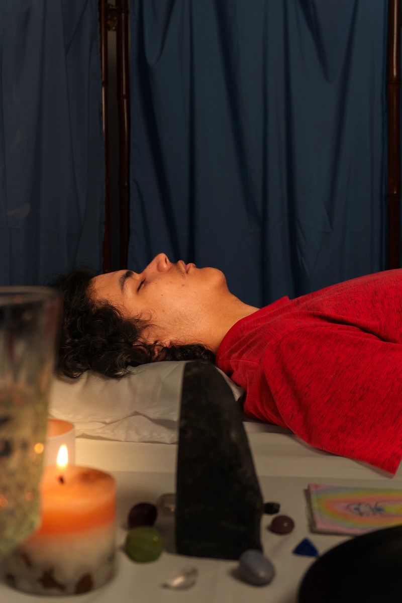 Patient resting during a reiki healing session with crystals, candles and other elements