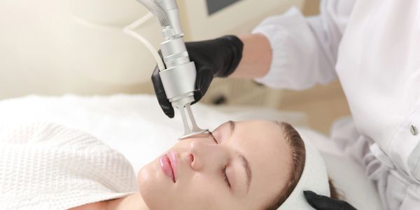 Woman receiving a facial laser treatment at a spa.